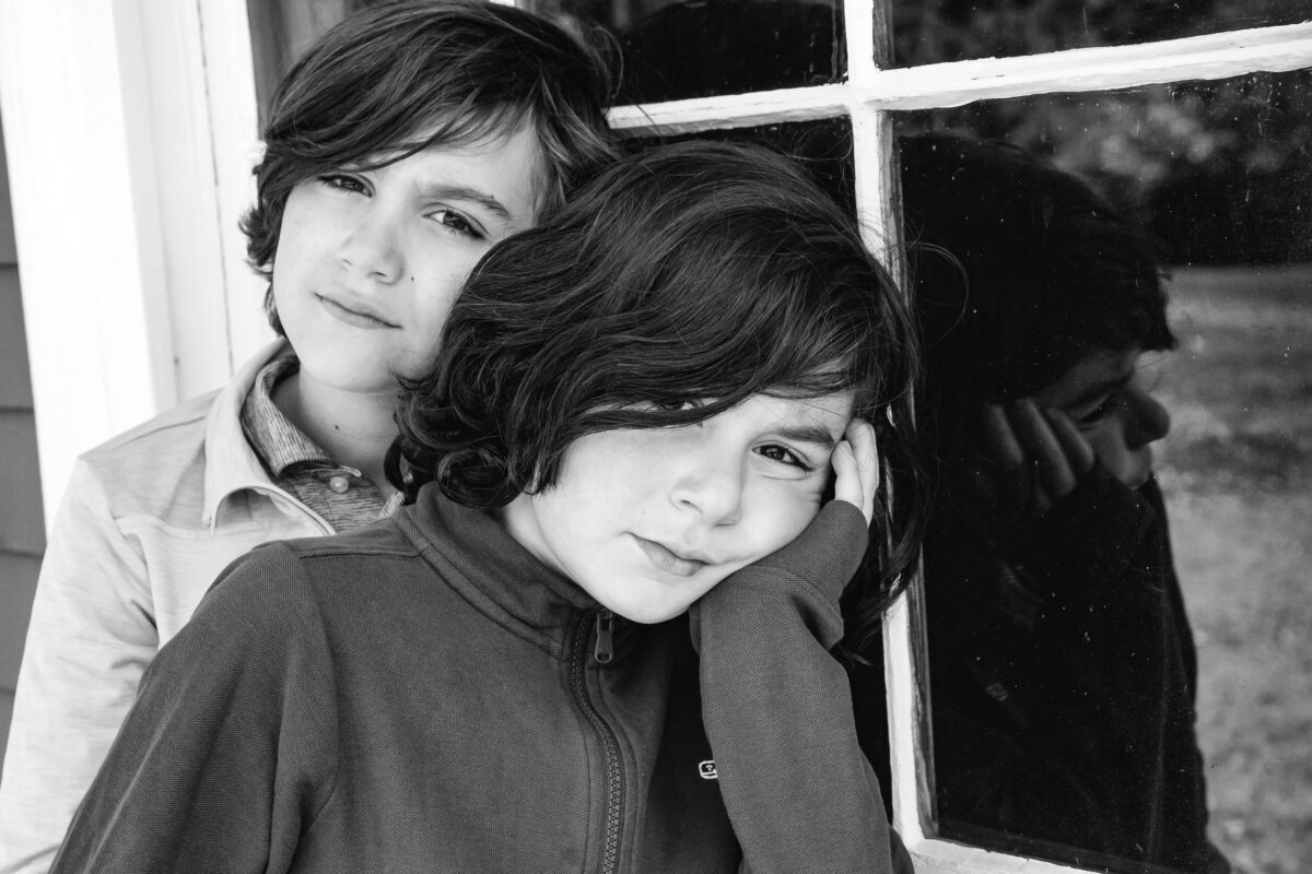 brothers standing close together and gazing thoughtfully at the camera during a session at Codman Farm