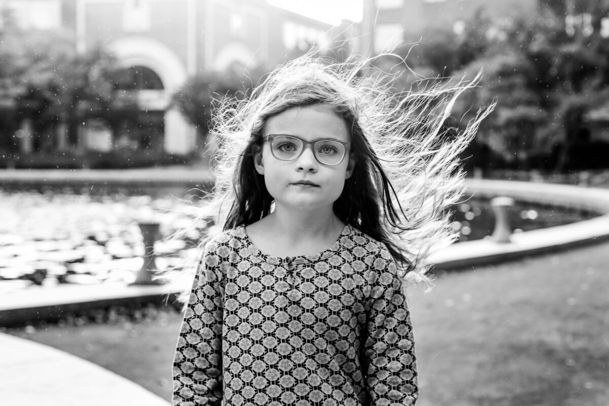 black and white photo of a girl with the wind whipping her hair